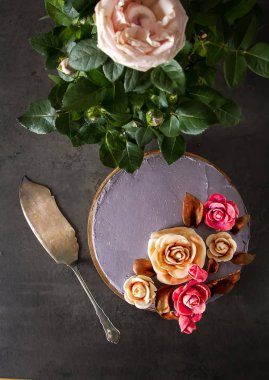 Çikolatalı pasta doğum günü için çiçekli. Koyu arka plan.