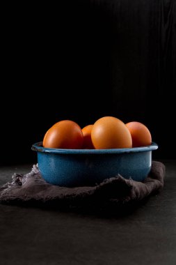 Bir tabak yumurta. Tavuk çiftliği. Koyu arka plan.