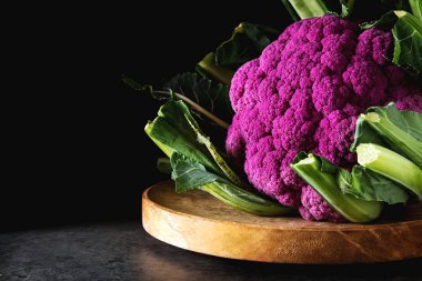 Karnabahar yeşil ve mor. Koyu arka plan. Vejetaryen yiyecekler.