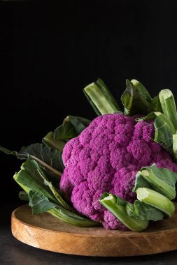 Karnabahar yeşil ve mor. Koyu arka plan. Vejetaryen yiyecekler.