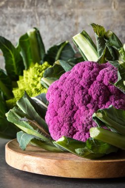 Karnabahar yeşil ve mor. Koyu arka plan. Vejetaryen yiyecekler.