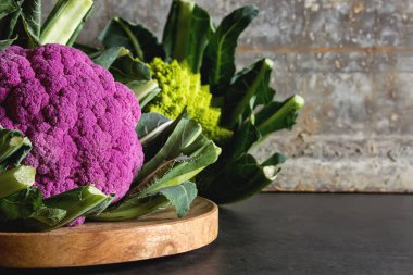 Karnabahar yeşil ve mor. Koyu arka plan. Vejetaryen yiyecekler.