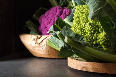 Karnabahar yeşil ve mor. Koyu arka plan. Vejetaryen yiyecekler.