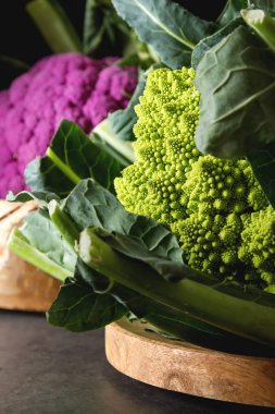 Karnabahar yeşil ve mor. Koyu arka plan. Vejetaryen yiyecekler.