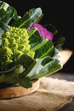 Karnabahar yeşil ve mor. Koyu arka plan. Vejetaryen yiyecekler.