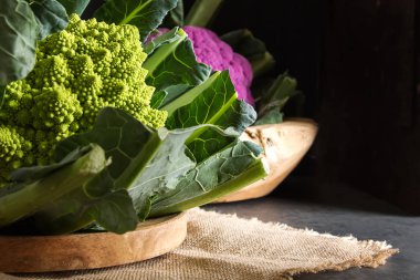 Karnabahar yeşil ve mor. Koyu arka plan. Vejetaryen yiyecekler.