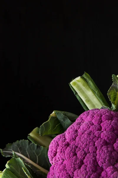 Cauliflower green and purple. Dark background. Vegetarian food.
