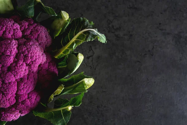 Цвітна капуста зеленого та фіолетового кольору. Темному тлі. Вегетаріанське харчування. — стокове фото
