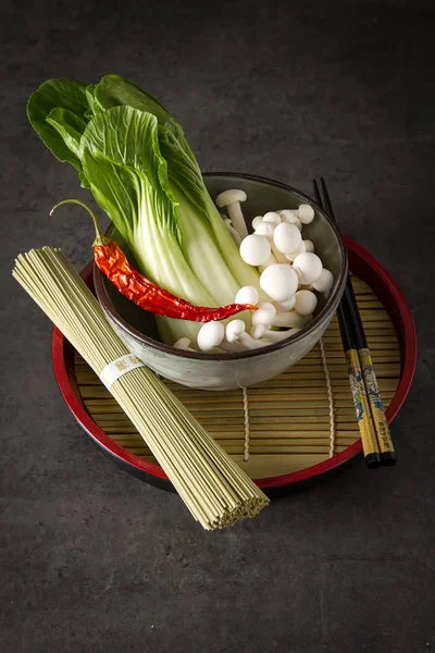 Traditional Chinese noodles with mushrooms, pack choy. Dark back