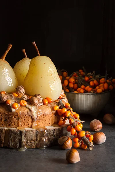 秋天的一餐。用梨、 大果沙棘和坚果的馅饼。黑暗的背景和目标 — 图库照片