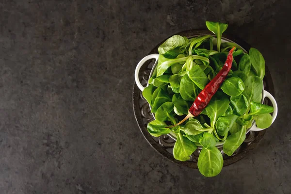 Ensalada verde con pimiento picante en un tazón blanco. fondo de piedra oscura —  Fotos de Stock