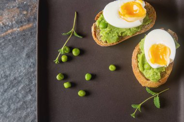 Baget püresi yeşil bezelye, yumurta ve nane ile. Koyu arka plan.