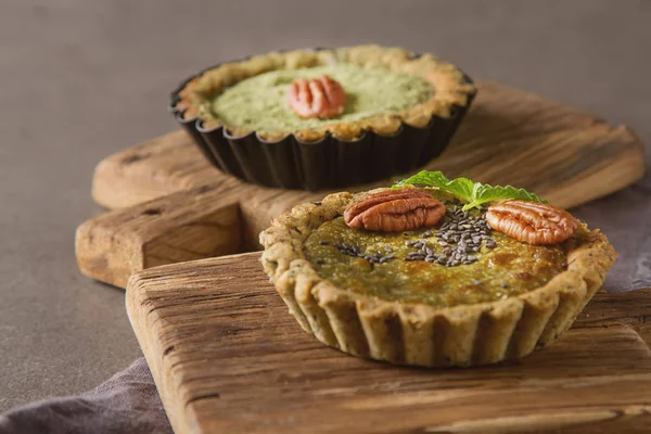 Green tea vegetarian pie match with nuts and mint. Dark backgrou