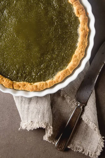 Green tea vegetarian pie match with nuts and mint. Dark backgrou