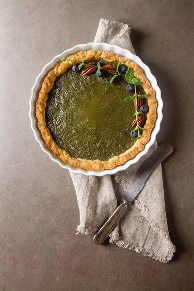 Green tea vegetarian pie match with nuts and mint. Dark backgrou