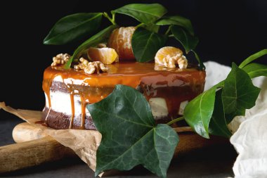 Beyaz krem ve karamel soslu çikolatalı kek. Koyu arka plan. Doğum günü