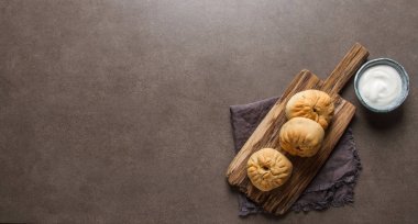 Geleneksel Rus etli börek, (belyashi) ekşi krema ile. Karanlık b
