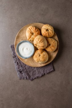 Geleneksel Rus etli börek, (belyashi) ekşi krema ile. Karanlık b