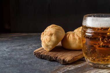 Geleneksel Rus etli börek, (belyashi) bira ile. Karanlık backgro