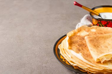 Ekşi krema ile bir tabakta krep yığını. Geleneksel th için