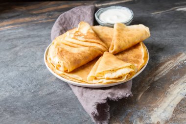 Ekşi krema ile bir tabakta krep yığını. Geleneksel th için