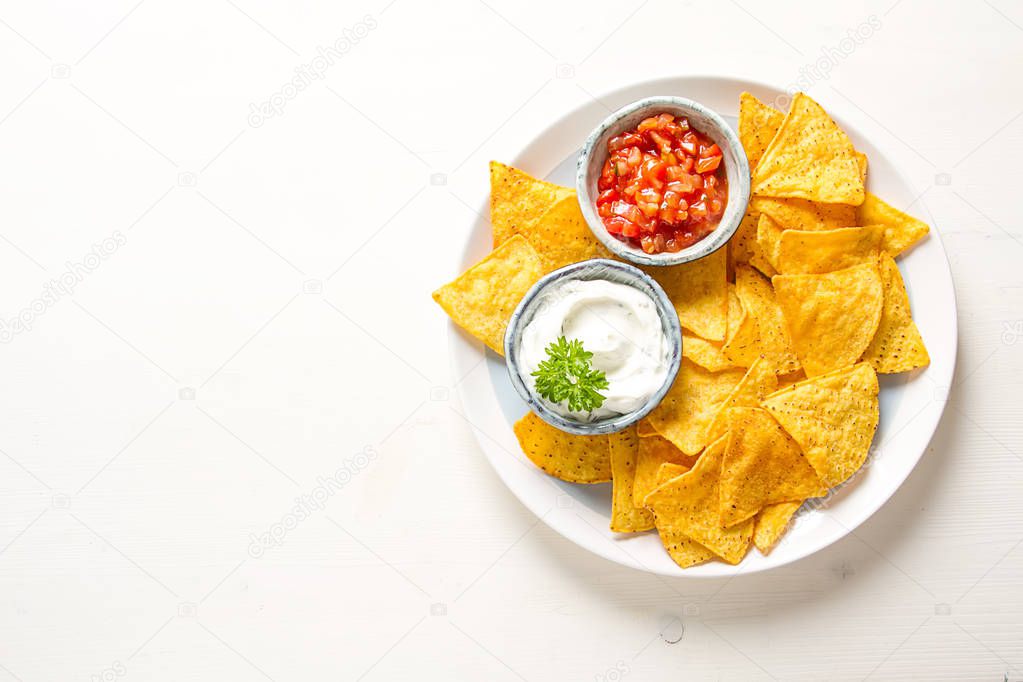 Snack for a party, chips with tortilla, nachos with sauces: sals