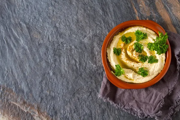 Vegetarian snack. Hummus with greens, dressed with olive oil and — Stock Photo, Image