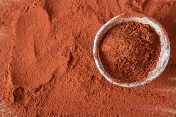 Natural cocoa powder in a clay bowl for chocolate and baking. Co