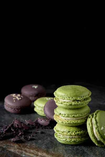 French dessert macaroons with pistachios and strawberries. Dark background