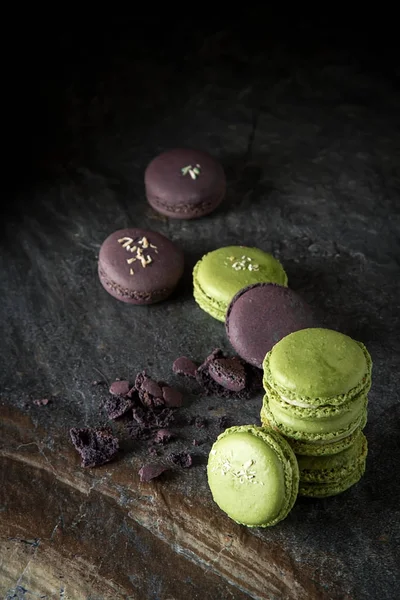 French dessert macaroons with pistachios and strawberries. Dark background