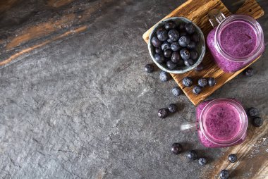 Taze sulu blueberry smoothies cam. Basit arka plan.