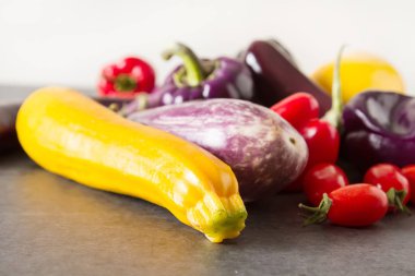 Küçük patlıcan, sarı kabak, domates ve mor biber. Dar