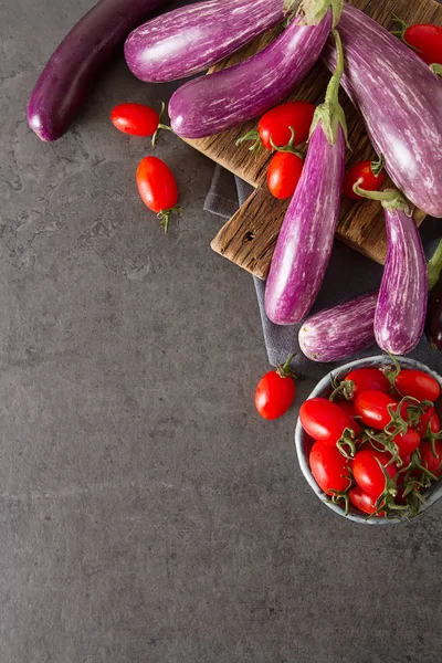 Small eggplants and tomatoes. Dark background. Vegetarian food f — Stock Photo, Image
