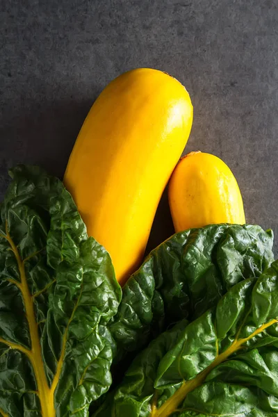 Calabacín amarillo, acelga. Fondo oscuro. Comida vegetariana de th —  Fotos de Stock