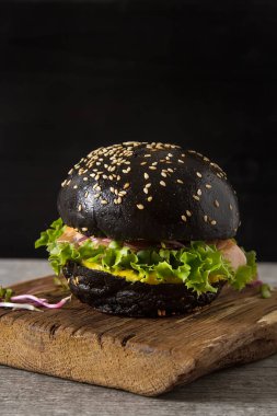 Somon Balık, marul, hardal ile siyah burger. Koyu arka plan