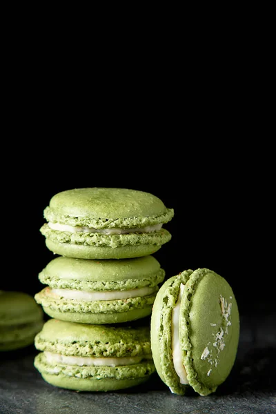 Macarrones de postre francés con pistachos y fresas. Fondo oscuro . —  Fotos de Stock