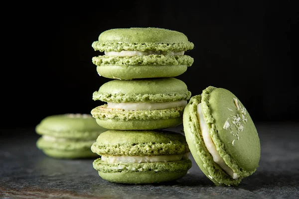 French dessert macaroons with pistachios and strawberries. Dark background. — Stock Photo, Image