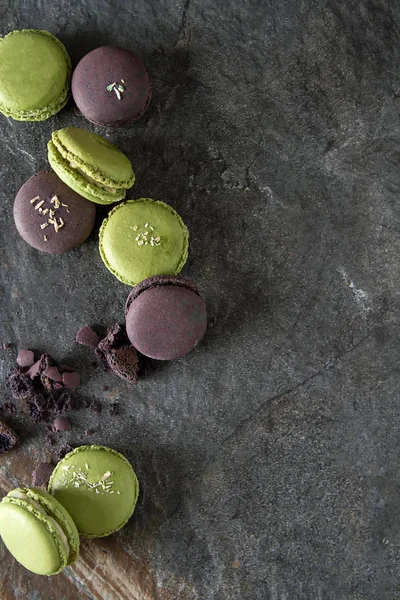 French dessert macaroons with pistachios and strawberries. Dark background. top view