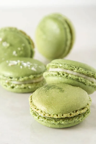 French dessert macaroons with pistachios and strawberries. White background.