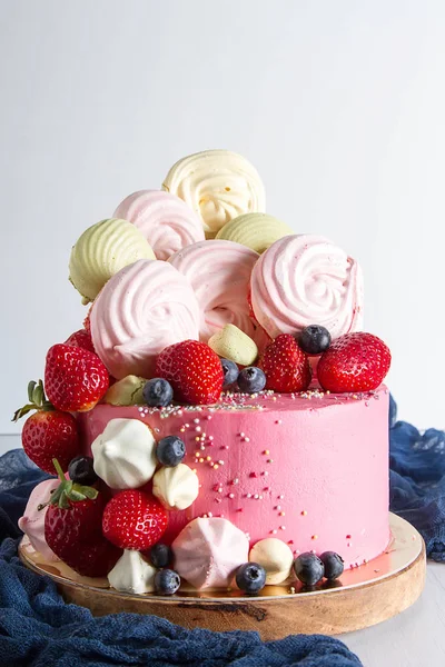 Birthday cake with meringue and berries. Delicious dessert for children. Light white background