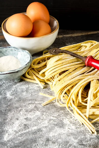 Tagliatelle italiano caseiro com farinha. Fundo escuro . — Fotografia de Stock