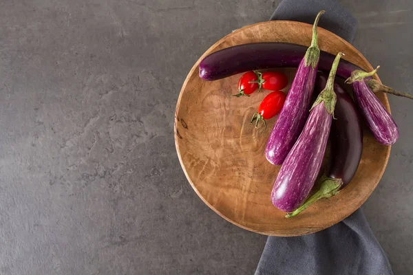 Small eggplants, tomatoes. Dark background. Vegetarian food from — Stock Photo, Image