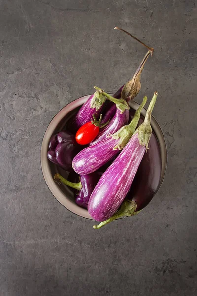 Malý lilek, rajčata. Tmavé pozadí. Vegetariánské jídlo od — Stock fotografie