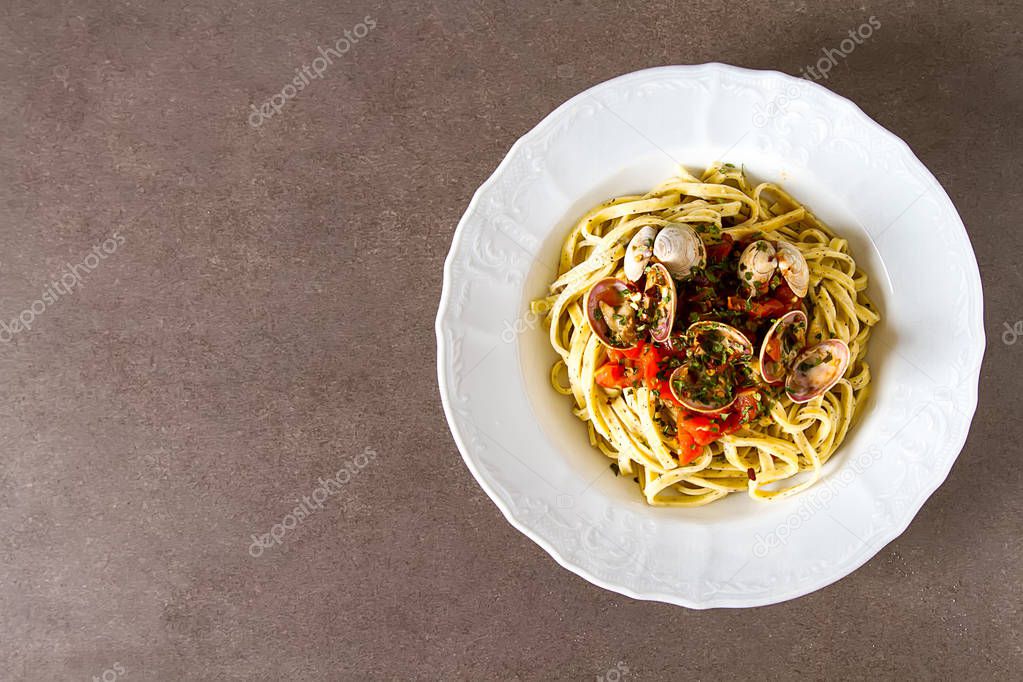 Italian tagliatelle in a restaurant with mussels and tomatoes. D