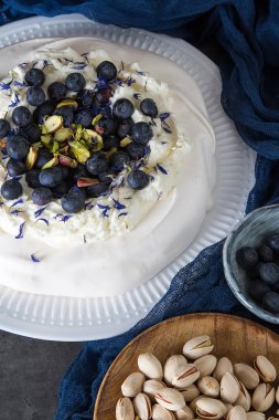 Yaban mersini, Antep fıstığı, mascarpone krema ile tatlı Pavlov. Beze gelen hafif tatlı. Koyu arka plan