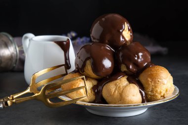 Dondurma ve çikolata sause ile profiterol. Koyu arka plan