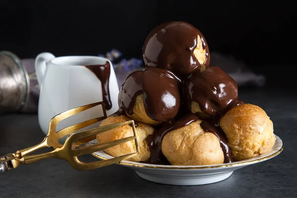 Dondurma ve çikolata sause ile profiterol. Koyu arka plan