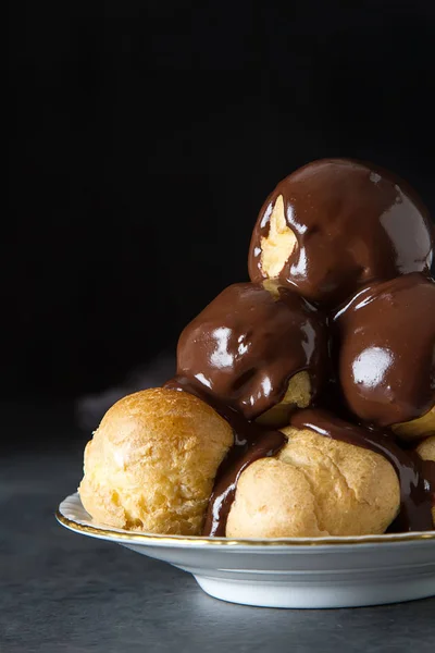 Dondurma ve çikolata sause ile profiterol. Koyu arka plan