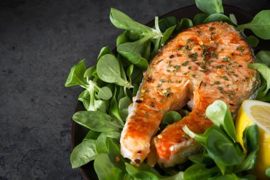 Izgara somon steak limon ve baharatlar ile. Taze balık pişirdim. Restoran Menü. Koyu arka plan