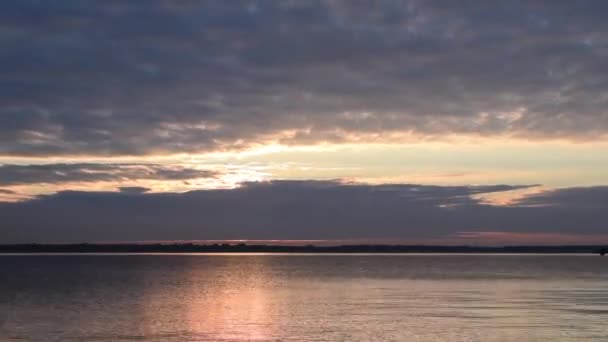 Časová prodleva s vycházející slunce svítí skrz mraky nad jezerem — Stock video
